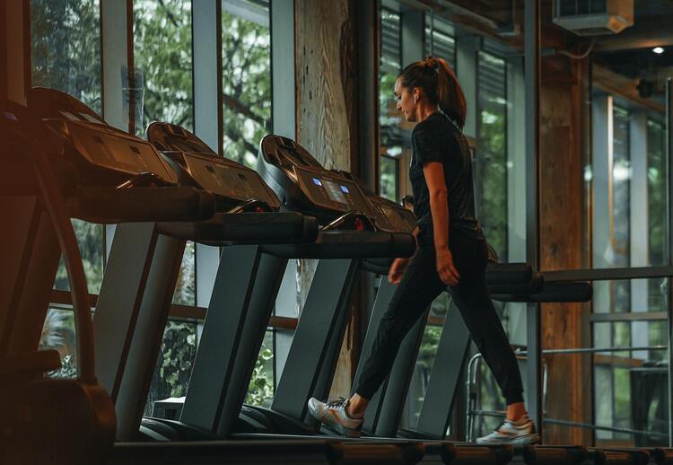 Frau läuft auf einem Laufband im Fitnessstudio.