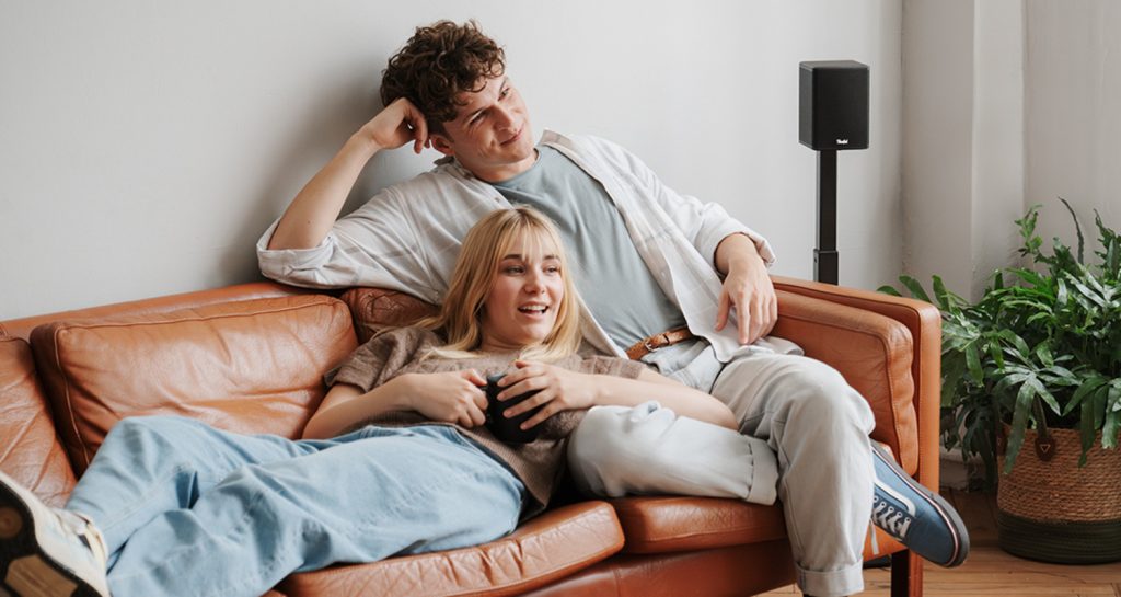 Una pareja se sienta en el sofá a escuchar música